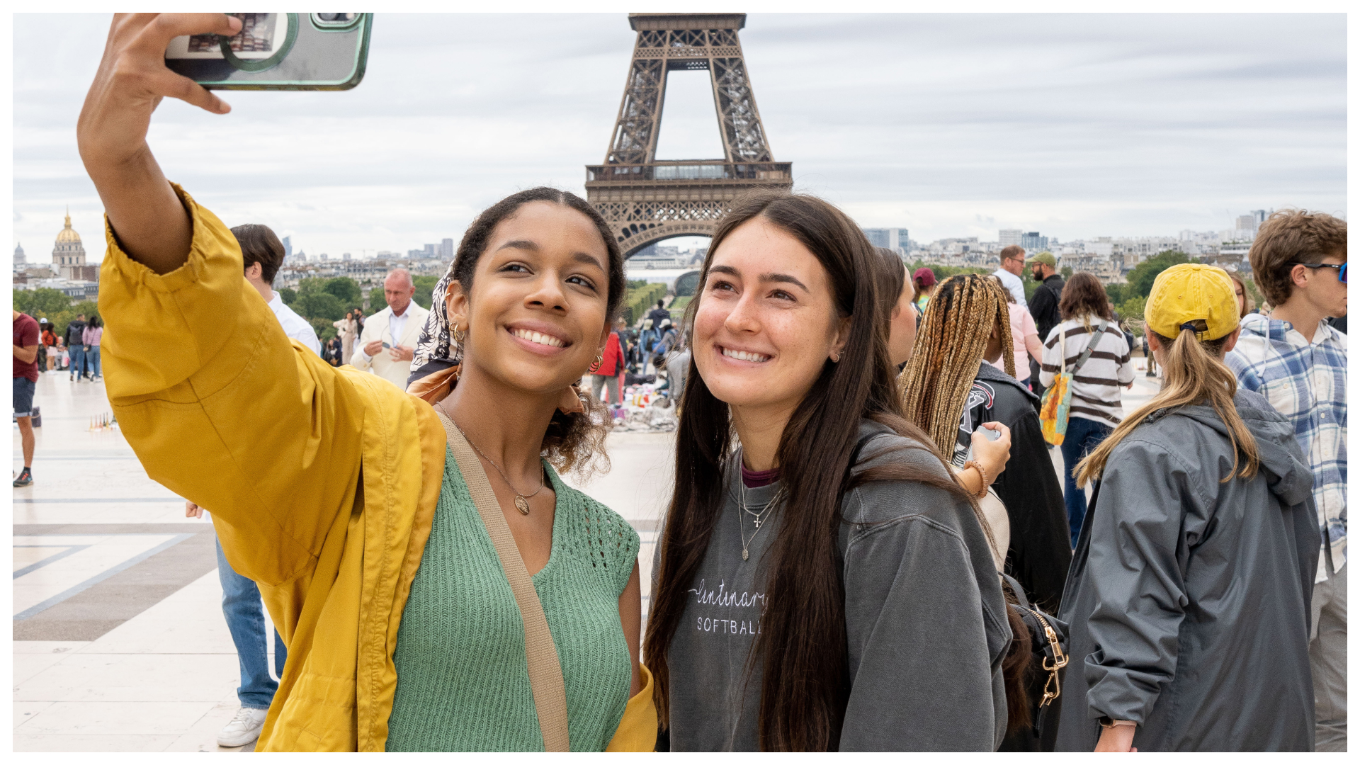 two students taking a selfie in front of the Eiffel Tower