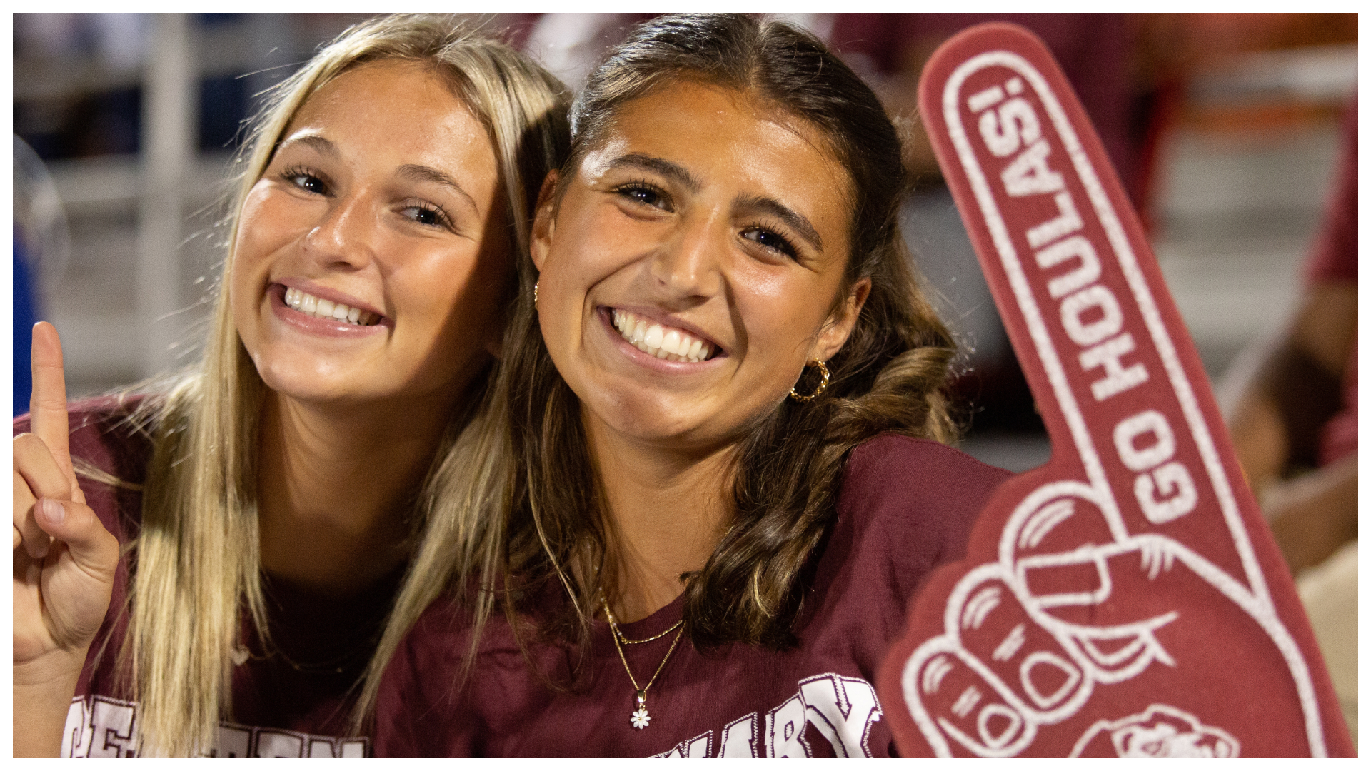 two students smiling at the camera attending a gaem