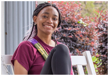 Centenary student sitting on chair on porch